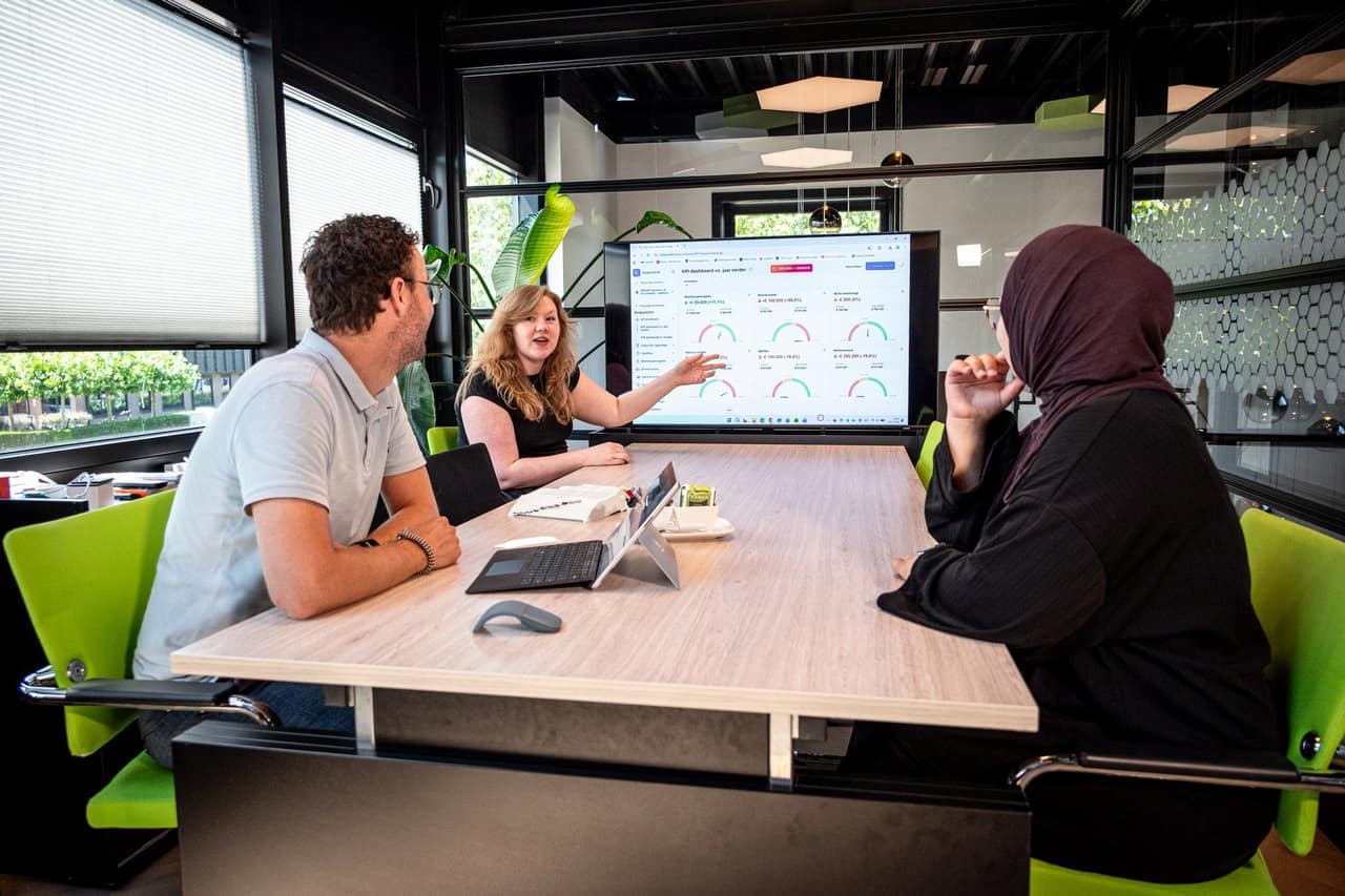 Twee collega's van iQOUNT werken samen achter een beeldscherm in Harderwijk
